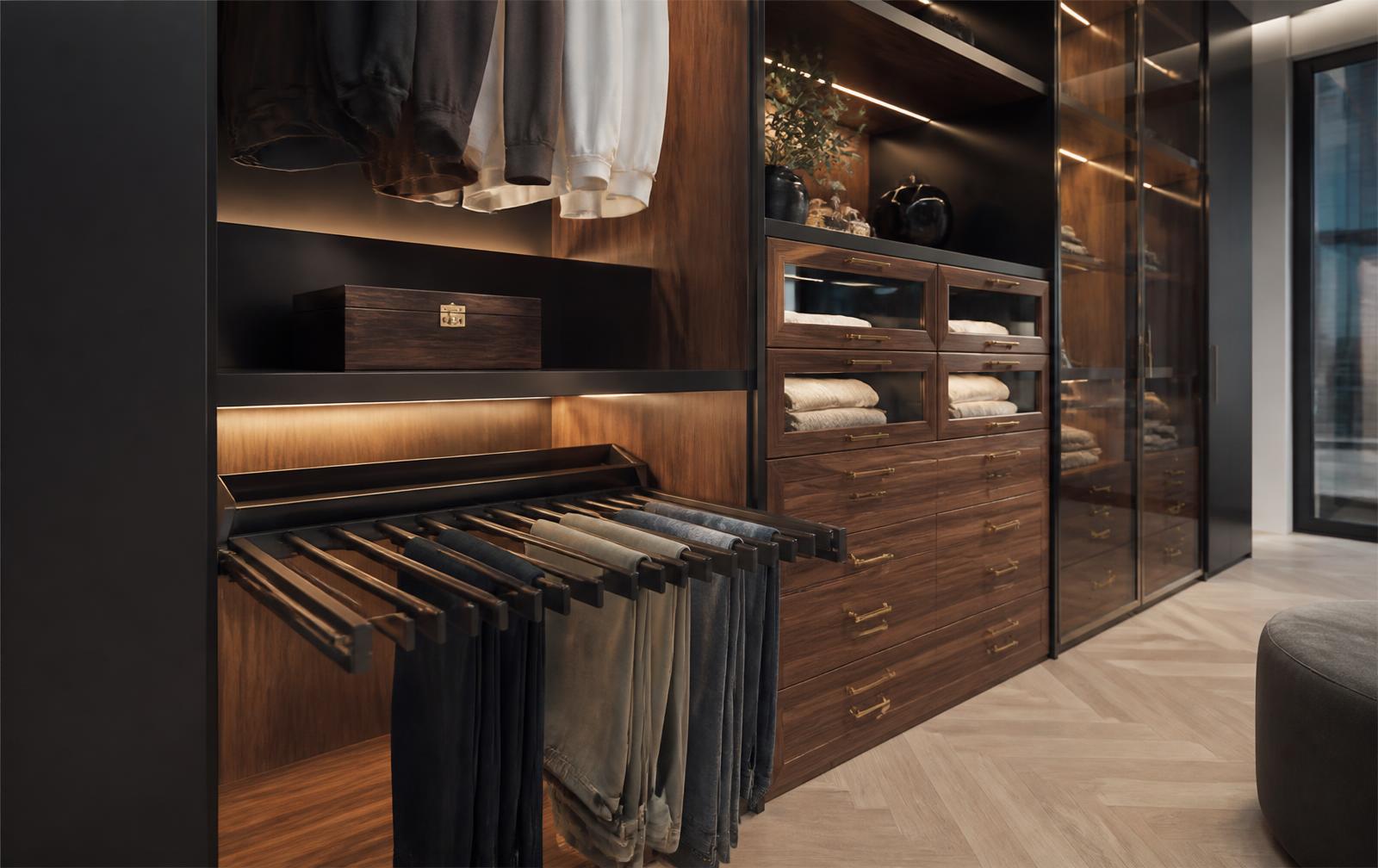Luxury walk-in wardrobe with walnut cabinetry, pull-out trouser rack, glass-front drawers and warm LED lighting