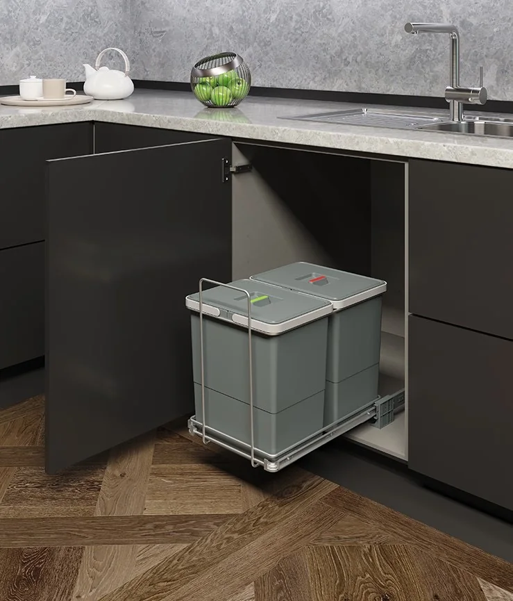 Ecofil pull-out waste bin Ecofil twin-bin pull-out waste bin on a wire frame in a dark modular kitchen base cabinet