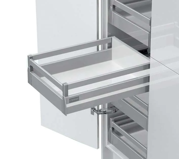 Metal-sided drawer with rectangular railing and Grass branding, pulled out of a white kitchen tall unit on concealed slides