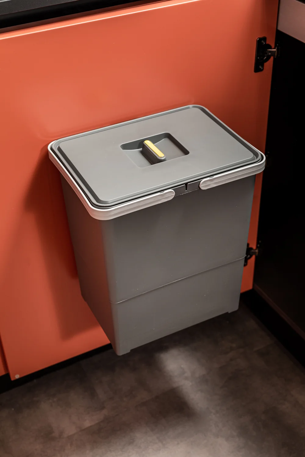 Swing door-mounted waste bin Grey Swing door-mounted waste bin with hinged lid fixed to a terracotta modular kitchen cabinet door
